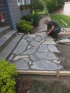 a man is working on a patio with flagstone