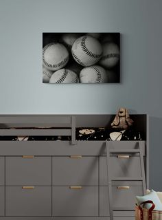 a bedroom with a bunk bed, dresser and baseballs on the wall above it