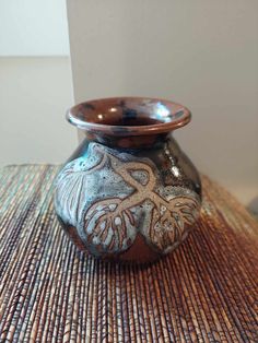 a brown and blue vase sitting on top of a table