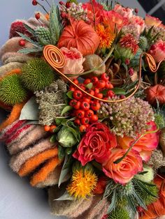 an arrangement of flowers and foliage on a table