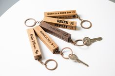 four wooden keychains with different types of keys attached to each other on a white surface