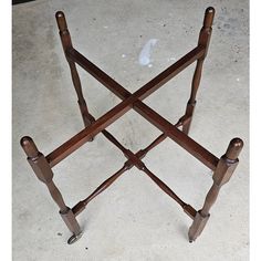 a wooden table with four legs and two handles on the top, sitting in a room