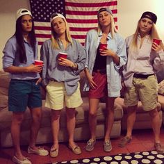 four girls standing in front of an american flag holding cups and looking at the camera