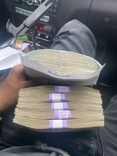 a person is holding stacks of money in their car