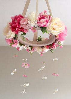 a pink and white flowered wreath hanging from a chandelier