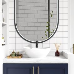 a bathroom sink with a large round mirror above it and blue cabinets in the background