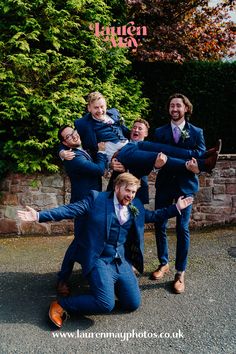 a group of men in suits and ties posing for the camera with their arms around each other