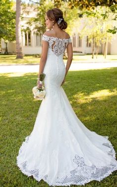 a woman in a wedding dress standing on the grass