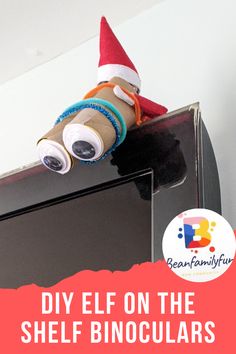 an elf is sitting on top of a shelf with the words diy elf on the shelf binoculars