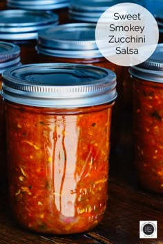 several jars filled with different kinds of food on top of a wooden table and the words sweet smokey zucchini salsa above them