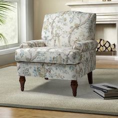 a chair sitting on top of a rug in front of a window next to a fire place