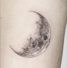 a small tattoo on the side of a woman's thigh with a half moon