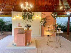 a table with flowers and candles on it in front of a wall that has a chandelier