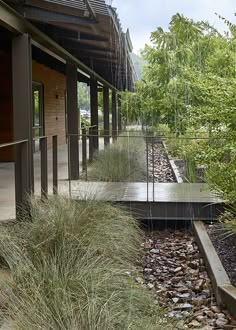 there is a walkway that leads to the side of a building with plants growing on it