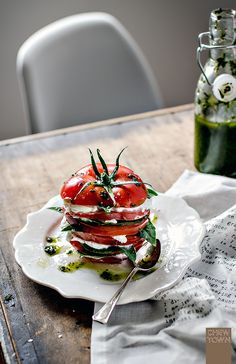 a stack of tomatoes sitting on top of a white plate