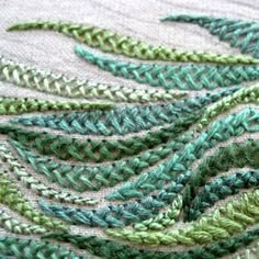 close up view of green and white crocheted fabric with wavy lines on it