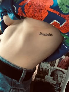 the back of a woman's stomach with an inscription on it that reads feminist