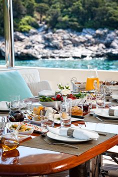 the table is set with food and drinks for two people to enjoy on their boat