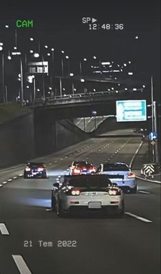 two cars driving down a highway at night