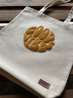 an embroidered bag sitting on top of a wooden bench