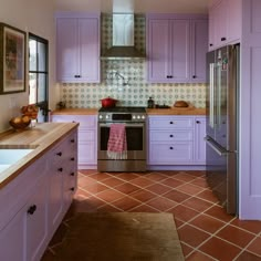 a kitchen with purple cabinets and tile flooring