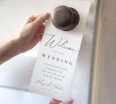 a person holding a doorknob with the word welcome to our wedding written on it