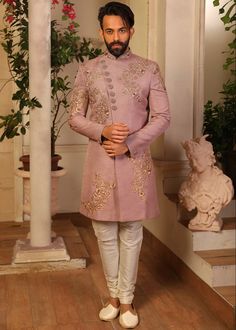 a man in a pink sherwa with white pants