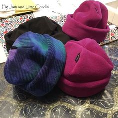 three different colored hats sitting on top of a table