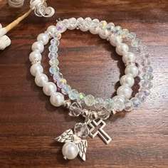 New Sparkly Boujee White Beaded Bracelet With Angel And Cross Charms, Paired With Iridescent Beaded One Strand Bracelet Set. Perfect For Wedding, Religious Events, Baptism Confirmations, Showers Gifts. Pics Do Not Capture The Beautiful Sparkle From These Beads. Bundle Several Items From My Closet And I’ll Give You A Great Deal! Plus You Maximize The Shipping Fee. Poshmarks Shipping Fee Covers Up To 5lbs Of Items! Free Gift With Every Purchase If You’re New To Poshmark Sign Up Using My Link Https Pearl Beaded Rosary Bracelet With Round Beads, Cross Charm Bracelet, Adjustable White Crystal Pearl Bracelet, White Crystal Pearl Bracelet Gift, White Crystal Jewelry With 8mm Beads, White Faceted Beads Rosary Bracelet Gift, White Crystal Bracelet With Round Beads, Adjustable White Crystal Beaded Bracelets, Beaded Bracelets Charms