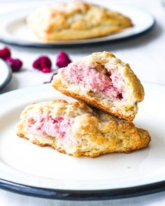 two pastries on a plate with raspberries