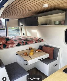 the interior of a camper with a kitchen table and bench in front of it