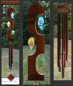 three different wind chimes hanging from the side of a building in front of trees