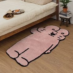 a pink rug with a cat on it in front of a bed