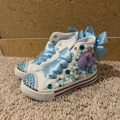 Custom Look A Like Converse, Kids Elsa Shoes ! Have Diamonds And Pearls Around It With Satin Lace Bow ! Condition: New Brand: Zebra Acydy / Custom Made Size: 11 / 17 Cm Message Me With Any Questions:) Cute Blue Slip-on Sneakers, Light Blue Sneakers For School, Cute Blue Sneakers For School, Light Blue Round Toe Sneakers For School, Cute Blue Non-slip Sneakers, Elsa Shoes, Bling Baby Shoes, Frozen Shoes, Barbie Photos