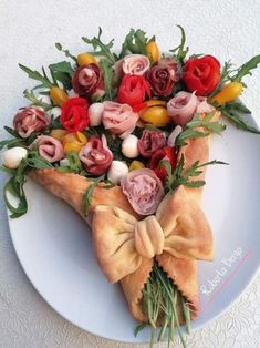 a white plate topped with a piece of pizza covered in lots of flowers and greenery