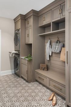 a washer, dryer and cabinets in a room