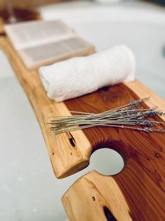 a close up of a wooden bench near a bath tub with a towel on it