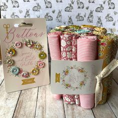 some pink and gold paper with buttons on it next to a card that says buttons