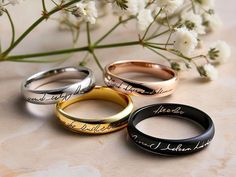 three different types of wedding rings with the names of two people and one is engraved on it