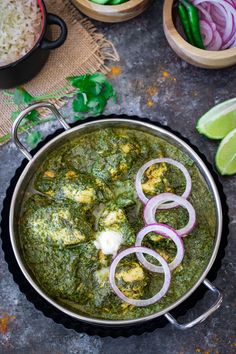 a pan filled with green curry and onions