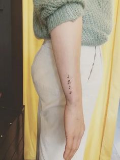 a woman's arm with a small tattoo on the left side of her right arm