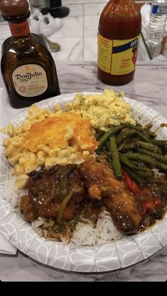 a paper plate filled with rice, meat and veggies next to condiments