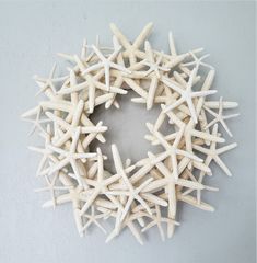 a wreath made out of white starfish on a gray background with space for text