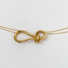 Designer Notes + Wear it as a long necklace or wear a choker. This hand crafted knot pendant necklace is a beautiful classic piece for everyday necklace. Layer with your favorite necklaces. DETAILS + •Color/ Material: 18K Solid gold plated Sterling Silver • Size: 16- 18 inches long size adjustable and also comes with an extra chain to wear as a choker. • Handcrafted in New York City. • Care: Keep airtight to maintain color and shine. Shipping + This item is in stock, ships in 1 to 2 business day Pendant Knot, Knotted Necklace, Knot Jewelry, Long Necklace Designs, Long Gold Necklace, Elegant Hand-knotted Lariat Necklaces, Gold Knot Necklace, Elegant Silver Hand-knotted Necklace, Lovers Knot Jewelry