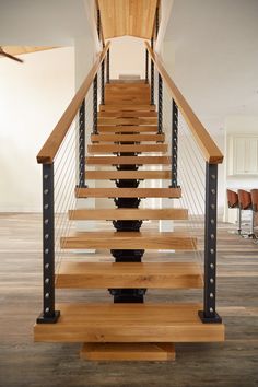 a wooden staircase with metal railings in an empty room