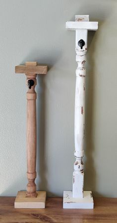 two wooden poles are standing next to each other on a shelf in front of a wall