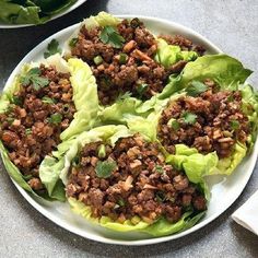 three tacos with meat, lettuce, tomatoes, and avocado