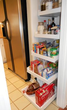 an open refrigerator with food in it and some shoes on the floor next to it