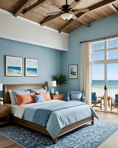 a bedroom with blue walls and wooden ceiling, along with a large bed in front of a window overlooking the ocean