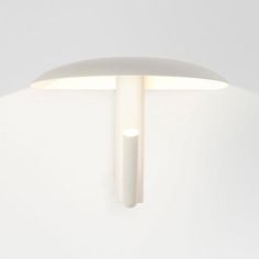 a white wall mounted light on the side of a wall